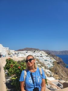 "Vanja Keindl standing in front of Santorini whitewashed houses, highlighting harmony between person and landscape"